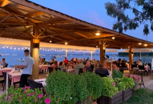 vollbesetzte abends Taverne am Strand, Korfu